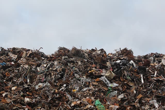 food waste and garbage mixed up adn piled in a wall of garbage at the landfill