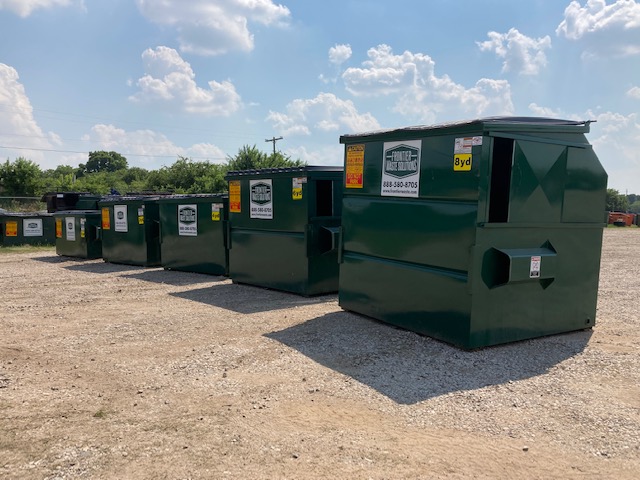commercial dumpsters lined up according to size